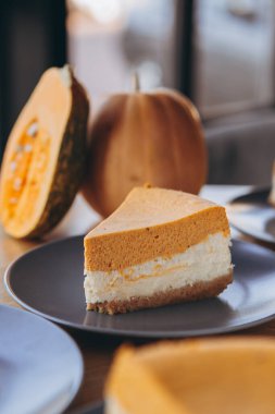 Bir parça balkabağı ev yapımı kek. Bayramlık tatlı konsepti. kabak turtası, rahat kafe arka planı, seçici odak, gürültü efekti