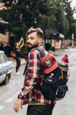 Şık sakallı turistin Tiflis 'in eski şehrinin sokaklarında dolaşıp fotoğraf çekerken ve insanlarla konuşurken çekilmiş bir fotoğrafı.