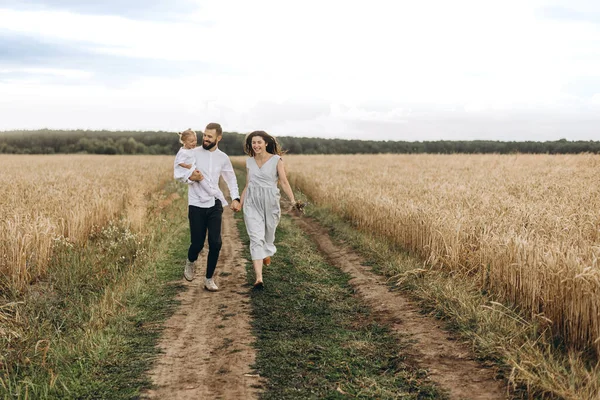 밭에서 산책하는 아버지와아 귀여운 아내와 부모와 아기와 — 스톡 사진