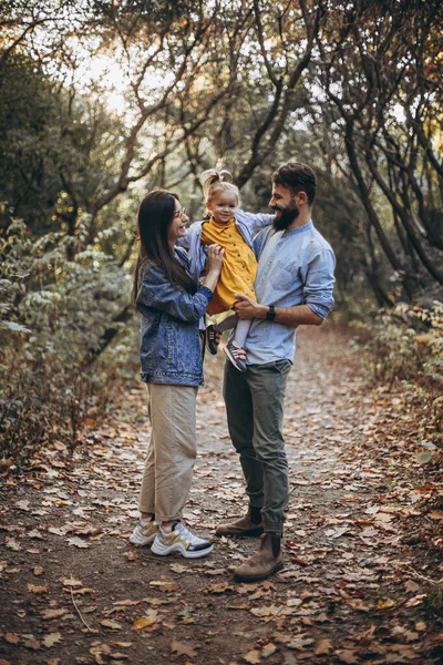 秋の公園を歩いている若いスタイリッシュなヒップスターの幸せな家族と彼らの甘い娘は晴れた天候を楽しんで — ストック写真