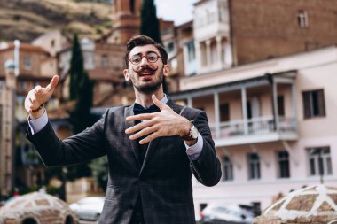 Gürcü, Gürcistan 'ın yerel konukseverliğinden bahseden şık bir adam, sizi eski sokaklarda gezinmeye ve yerel mutfağın tadına bakmaya davet ediyor. Turizmi desteklemek için.