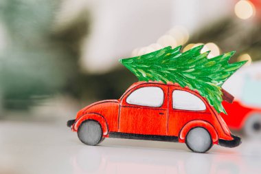 Kış arka planında Noel ağacı olan neşeli çelenklerle dolu bir oyuncak araba. Metnin için bayram kartı, afiş ya da yer kavramı
