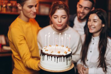 Çekici bir kadın doğum gününde dilek tuttuktan sonra pastadaki mumları söndürür. En iyi arkadaşlardan oluşan bir grup tatildeki kız arkadaşını tebrik etmeye geldi.