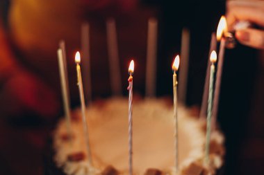 Arkadaşlar sevgililerinin doğum günü pastası için mum yakarlar.