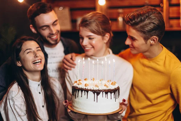 照片中 一个快乐的女孩拿着生日蛋糕 身边的朋友们欢欢喜喜地庆祝着她的生日 — 图库照片