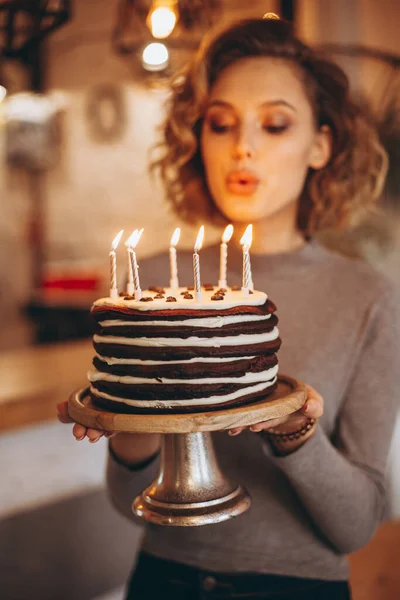 许个愿吧年轻漂亮的姑娘要许个愿 把所有的蜡烛都吹灭了 自制的蛋糕 点着蜡烛 有选择的焦距 噪音效果 — 图库照片