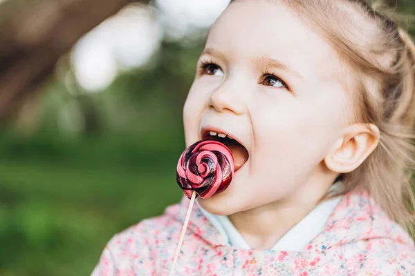 Klein Jarig Meisje Likt Een Gekleurde Wervelende Snoep Een Wandeling — Stockfoto