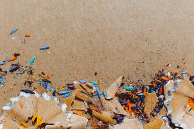 seçici odak: çizim dersindeki bir sanatçının ya da öğrencinin yaratıcı atmosferi: keskinleştirilmiş renkli kalemlerden talaş toplayan bir masa