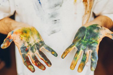 Bir resim oluşturma sürecinde ressamın elleri boyayla boyandı. Boşluğu kopyala