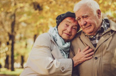 Yaşlı bir çift bankta oturuyor ve üzgün üzgün üzgün aşağı bakıyor. Sum, üzüntü, yaşlılık, can sıkıntısı, acı, kayıp, yıkım duygusu.