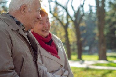 Autumn Park 'ta mutlu bir son sınıf çifti. Konuş, şaka yap ve gençliği hatırla. Olgun çift dışarıda.