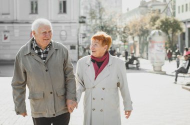 Mutlu yaşlılar güneşli bir günde parkta yürüyüş yapıyorlar. Eski aile kavramı.. 
