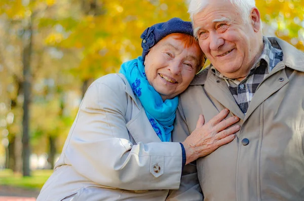 Love lives forever! Senior couple at outdoors. Very old man and attractive old woman are hugging and enjoying spending time together.