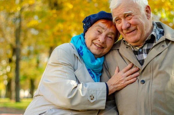 Love lives forever! Senior couple at outdoors. Very old man and attractive old woman are hugging and enjoying spending time together.