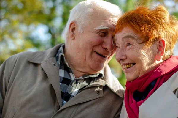 Portrait of an old happy romantic couple outdoors. Senior mature couple of people in autumn park