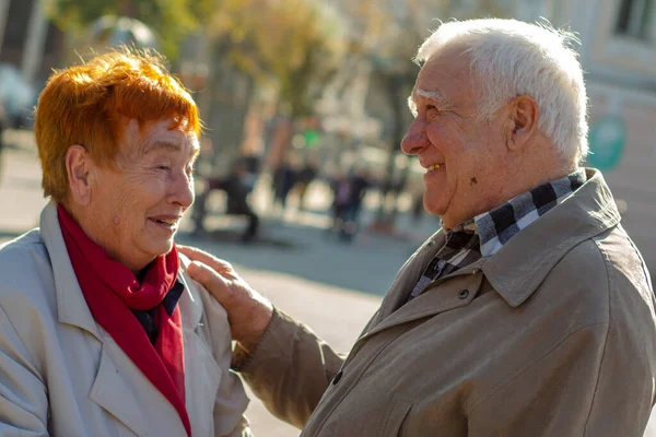 A couple of elderly people. Grandfather and granddaughter on a walk in the park. An old couple of husbands and wives walk in the autumn in the city. senior couple in love