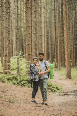 Çocukları olan aile gezgin ormana doğru yürürken