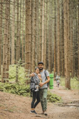Çocukları olan aile gezgin ormana doğru yürürken