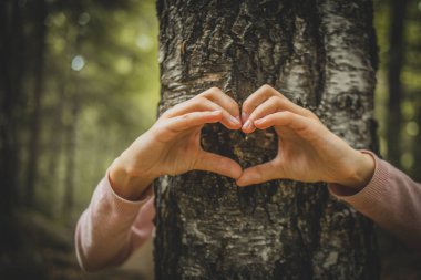 Kalbini ağaçla paylaşan bir kız.