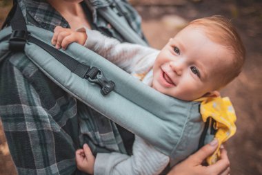 Anne ve bebeği bir kanguru sırt çantasında ya da dağlarda ve ormanlarda dolaşırken askıda.