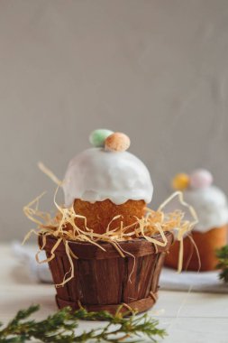 Paskalya arkaplanız kutlu olsun. Cilalı, çikolatalı ve küçük yumurtalarla süslenmiş paskalya pastası. Tebrik kartı, reklam, promosyon, poster, broşür, internet afişi, makale için resim. karmaşık kompozisyon, güzel manzara, hareket, eller