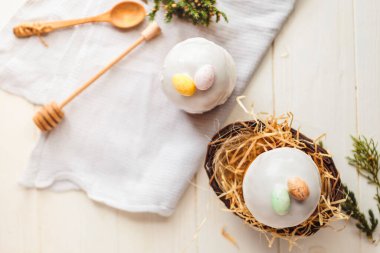 Paskalya arkaplanız kutlu olsun. Cilalı, çikolatalı ve küçük yumurtalarla süslenmiş paskalya pastası. Tebrik kartı, reklam, promosyon, poster, broşür, internet afişi, makale için resim. karmaşık kompozisyon, güzel manzara, hareket, eller