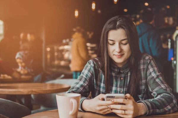 Portret Szczęśliwej Uśmiechniętej Brunetki Która Trzyma Ręku Telefon Komórkowy Przepisując — Zdjęcie stockowe