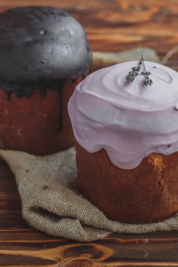 Paskalya arkaplanız kutlu olsun. Cilalı, çikolatalı ve küçük yumurtalarla süslenmiş paskalya pastası. Tebrik kartı, reklam, promosyon, poster, broşür, internet afişi, makale için resim. karmaşık kompozisyon, güzel manzara, hareket, eller