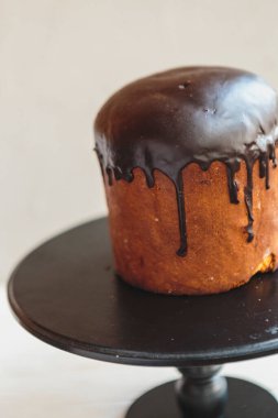 Paskalya arkaplanız kutlu olsun. Cilalı, çikolatalı ve küçük yumurtalarla süslenmiş paskalya pastası. Tebrik kartı, reklam, promosyon, poster, broşür, internet afişi, makale için resim. karmaşık kompozisyon, güzel manzara, hareket, eller