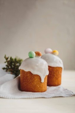 Paskalya arkaplanız kutlu olsun. Cilalı, çikolatalı ve küçük yumurtalarla süslenmiş paskalya pastası. Tebrik kartı, reklam, promosyon, poster, broşür, internet afişi, makale için resim. karmaşık kompozisyon, güzel manzara, hareket, eller