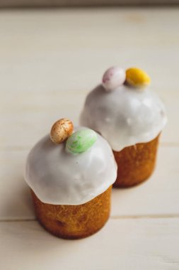 Paskalya arkaplanız kutlu olsun. Cilalı, çikolatalı ve küçük yumurtalarla süslenmiş paskalya pastası. Tebrik kartı, reklam, promosyon, poster, broşür, internet afişi, makale için resim. karmaşık kompozisyon, güzel manzara, hareket, eller