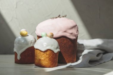 Paskalya arkaplanız kutlu olsun. Cilalı, çikolatalı ve küçük yumurtalarla süslenmiş paskalya pastası. Tebrik kartı, reklam, promosyon, poster, broşür, internet afişi, makale için resim. karmaşık kompozisyon, güzel manzara, hareket, eller