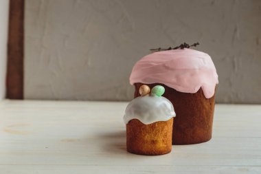 Paskalya arkaplanız kutlu olsun. Cilalı, çikolatalı ve küçük yumurtalarla süslenmiş paskalya pastası. Tebrik kartı, reklam, promosyon, poster, broşür, internet afişi, makale için resim. karmaşık kompozisyon, güzel manzara, hareket, eller