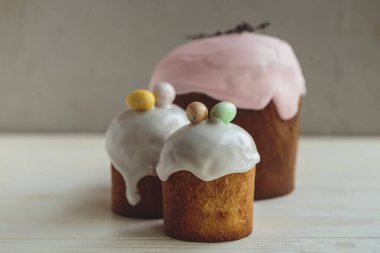 Paskalya arkaplanız kutlu olsun. Cilalı, çikolatalı ve küçük yumurtalarla süslenmiş paskalya pastası. Tebrik kartı, reklam, promosyon, poster, broşür, internet afişi, makale için resim. karmaşık kompozisyon, güzel manzara, hareket, eller