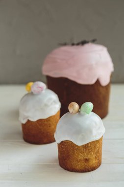 Paskalya arkaplanız kutlu olsun. Cilalı, çikolatalı ve küçük yumurtalarla süslenmiş paskalya pastası. Tebrik kartı, reklam, promosyon, poster, broşür, internet afişi, makale için resim. karmaşık kompozisyon, güzel manzara, hareket, eller