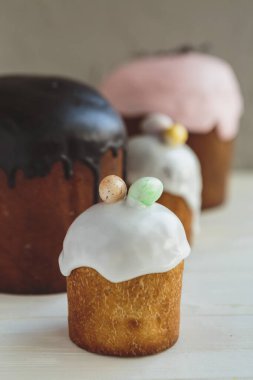 Paskalya arkaplanız kutlu olsun. Cilalı, çikolatalı ve küçük yumurtalarla süslenmiş paskalya pastası. Tebrik kartı, reklam, promosyon, poster, broşür, internet afişi, makale için resim. karmaşık kompozisyon, güzel manzara, hareket, eller