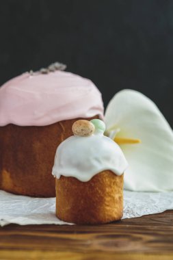 Paskalya arkaplanız kutlu olsun. Cilalı, çikolatalı ve küçük yumurtalarla süslenmiş paskalya pastası. Tebrik kartı, reklam, promosyon, poster, broşür, internet afişi, makale için resim. karmaşık kompozisyon, güzel manzara, hareket, eller