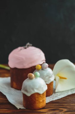 Paskalya arkaplanız kutlu olsun. Cilalı, çikolatalı ve küçük yumurtalarla süslenmiş paskalya pastası. Tebrik kartı, reklam, promosyon, poster, broşür, internet afişi, makale için resim. karmaşık kompozisyon, güzel manzara, hareket, eller