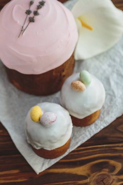 Paskalya arkaplanız kutlu olsun. Cilalı, çikolatalı ve küçük yumurtalarla süslenmiş paskalya pastası. Tebrik kartı, reklam, promosyon, poster, broşür, internet afişi, makale için resim. karmaşık kompozisyon, güzel manzara, hareket, eller