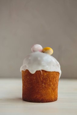 Paskalya arkaplanız kutlu olsun. Cilalı, çikolatalı ve küçük yumurtalarla süslenmiş paskalya pastası. Tebrik kartı, reklam, promosyon, poster, broşür, internet afişi, makale için resim. karmaşık kompozisyon, güzel manzara, hareket, eller