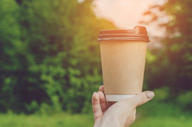 El ele tutuşup kahve fincanı. Doğal arkaplan üzerine yazdığınız metin için boş yeri olan bir paket kahve.