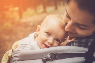 Anne ve bebeği bir kanguru sırt çantasında ya da dağlarda ve ormanlarda dolaşırken askıda.