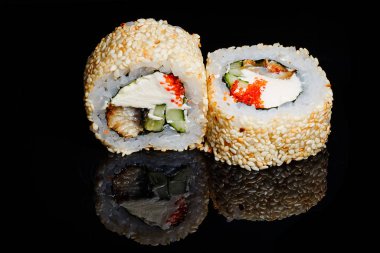 Suşi fotoğrafı ve siyah ayna arkaplanındaki roller.