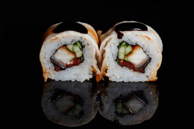 Suşi fotoğrafı ve siyah ayna arkaplanındaki roller.