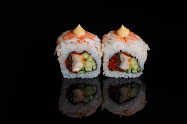 Suşi fotoğrafı ve siyah ayna arkaplanındaki roller.