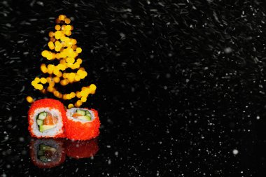 Real sushi pieces of rolls Japanese cuisine on black snow background. Chritmas. New year. clipart