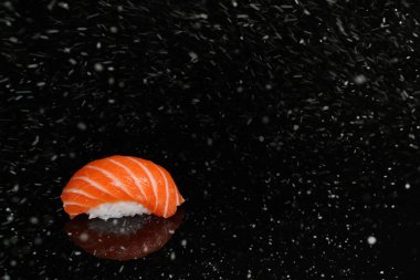 Siyah karlı zeminde gerçek suşi rulo Japon mutfağı. Noel 'de. Yeni Yıl.