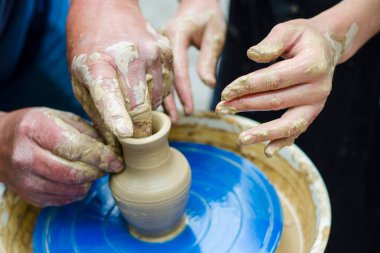 Birlikte yapıyoruz. Çömlekçi çocuğuna çömlek çarkında seramik tencere yapmayı öğretirken en iyi manzara. Çömlek atölyesi
