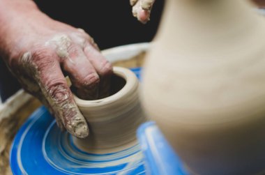 Potter işte. Çamurdan sürahi yapıyor. Çömlek atölyesi