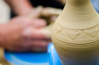 Çömlek atölyesindeki çömlekçi çarkında kil modellemesi üzerine sokak ustası sınıfı. Vazoya odaklan, vazoyu arka planda bulanıklaştırma işlemi